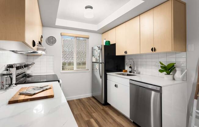 a kitchen with a white counter top and a stainless steel refrigerator