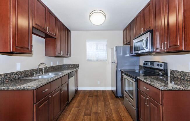 a large kitchen with stainless steel appliances and wooden cabinets