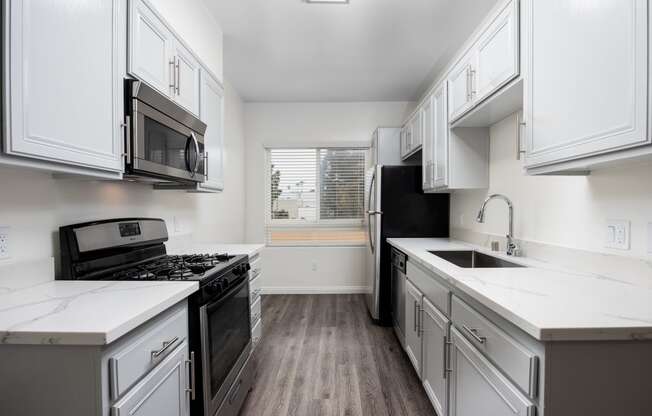 a kitchen with white cabinets and white countertops