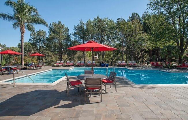 Pool with table and chairs Apartments in Pittsburg, CA l Kirker Creek Apartments