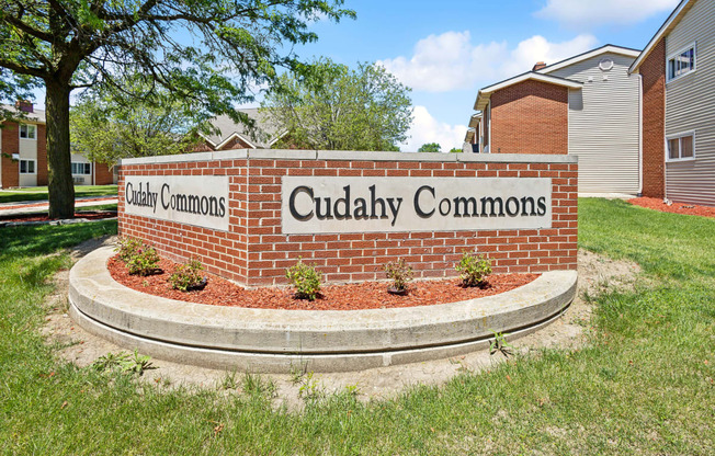 a brick monument sign for cuddly commons in front of a building