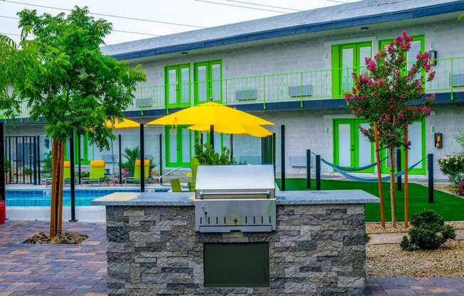 Fusion Las Vegas community barbecue with river rock islands and lush landscape next to community pool and hammocks