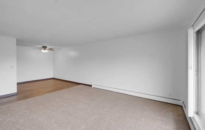 a bedroom with white walls and a ceiling fan