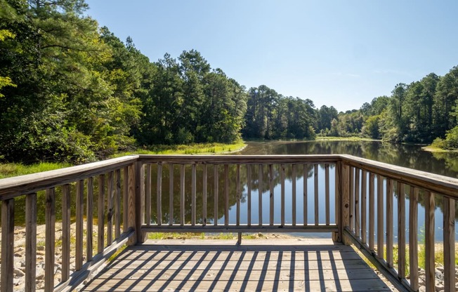 a view of a deck overlooking a lake with trees