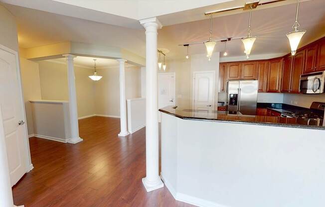 A kitchen with white countertops and wooden floors.