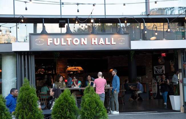 people standing outside of a restaurant with a sign at The Paxton, Brooklyn, NY