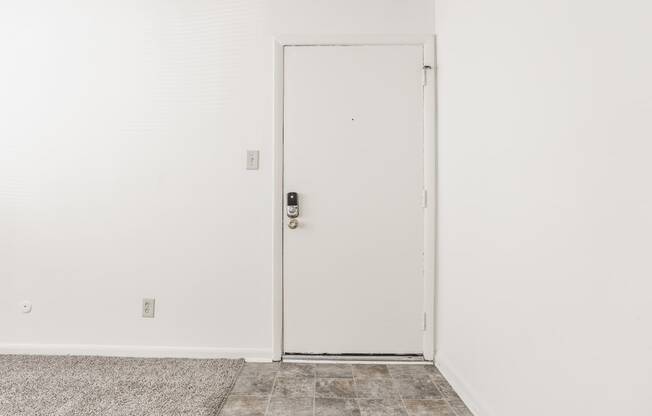 an open door in a room with white walls and a tile floor