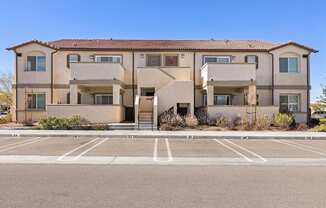 A large apartment building with a parking lot in front.