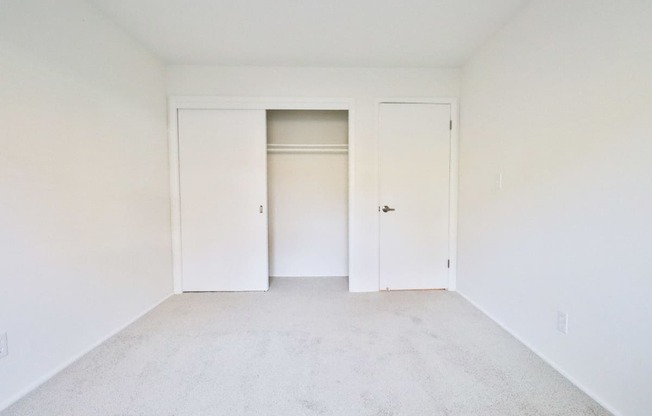 an empty room with white walls and white doors