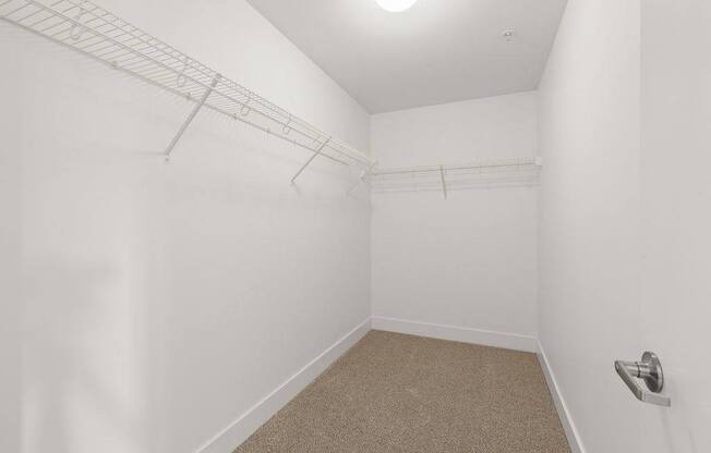 A white room with a carpeted floor and a light on the ceiling.