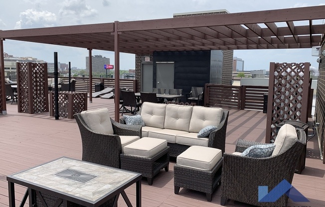 a roof deck with furniture and a pergola