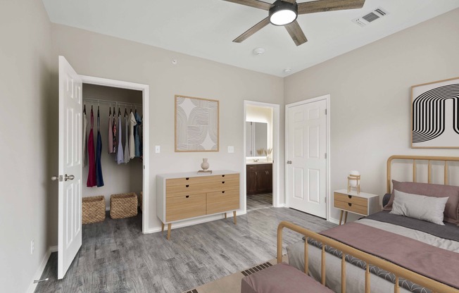 Bedroom with large closet, wood-style plank flooring, and ceiling fan.