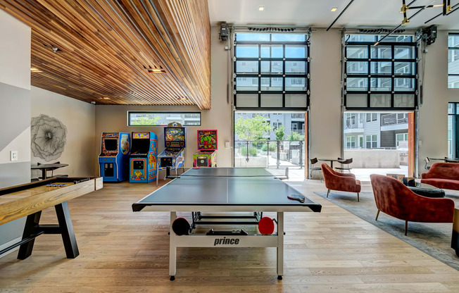 A ping pong table is in the middle of a room with a wooden ceiling.