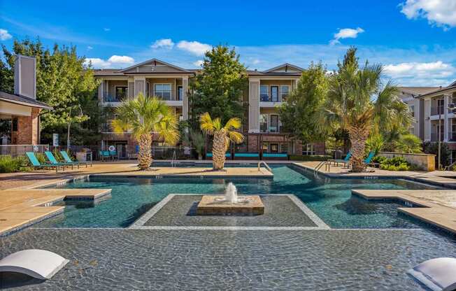 A pool with a fountain in the middle of it. at Bridge at Southpark Meadows, Austin, TX, 78748