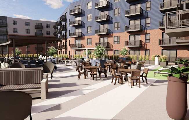 A modern outdoor seating area with tables and chairs is surrounded by apartment buildings.