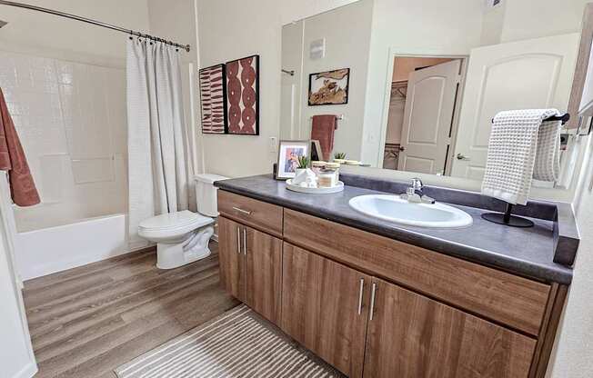 A bathroom with a toilet, sink, and shower.