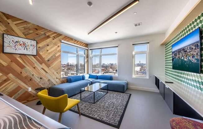 A living room with a yellow chair and a blue couch.