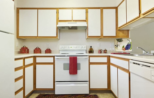 a kitchen with white appliances and wooden cabinets