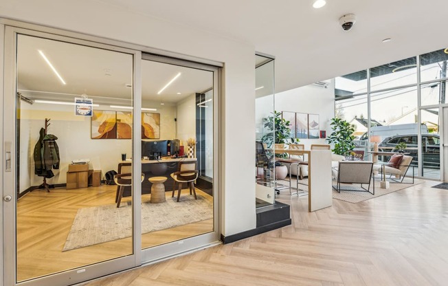 A modern office space with a glass door entrance and a view of the outside.