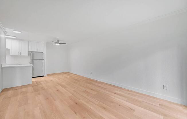 A room with wooden flooring and white walls.