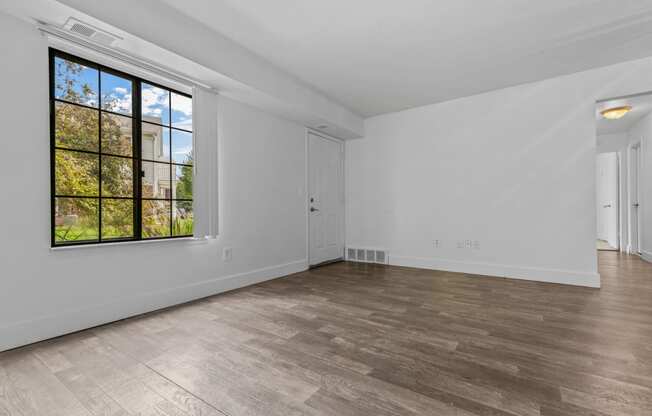 a bedroom with hardwood floors and a large window