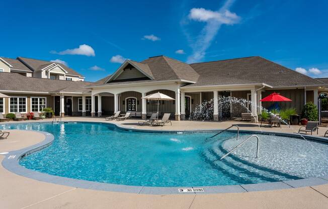 Resort-style swimming pool with view of clubhouse at Riverstone apartments in Macon, GA