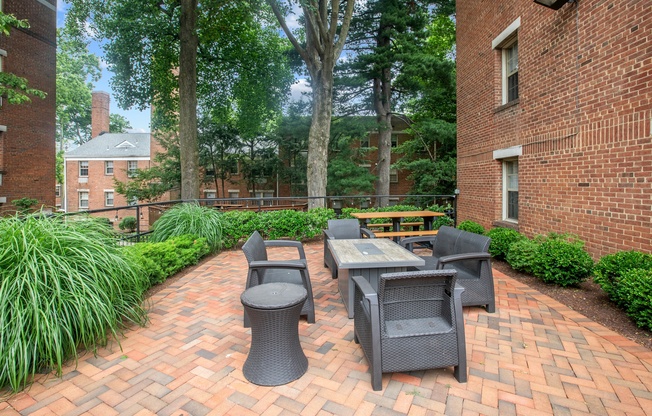 a brick patio with a table and chairs in front of a brick building