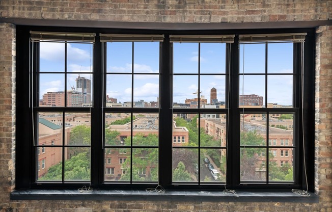 a large window in a brick wall with a view of the city at Gaar Scott Historic Lofts, Minnesota, 55401