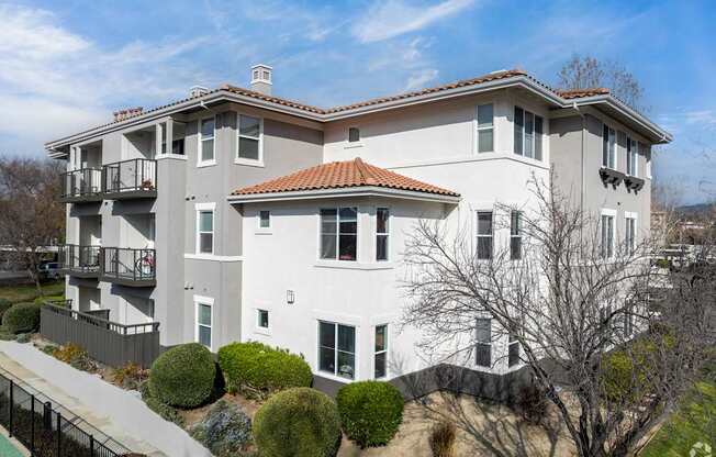 A large white house with a red tile roof and a balcony on the second floor at Cornerstone at Gale Ranch Apartments, San Ramon, CA
