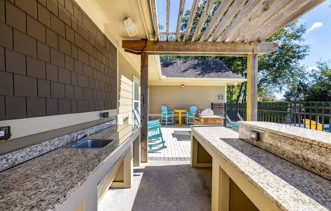 A kitchen with granite countertops and a wooden pergola.