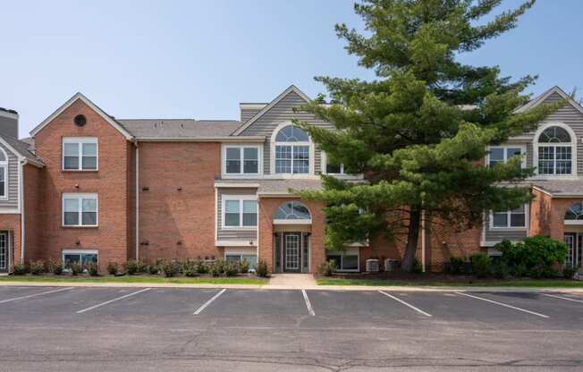 a large brick building with a large parking lot in front of it