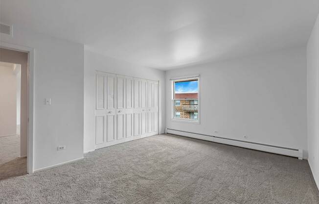 a bedroom with white walls and carpet