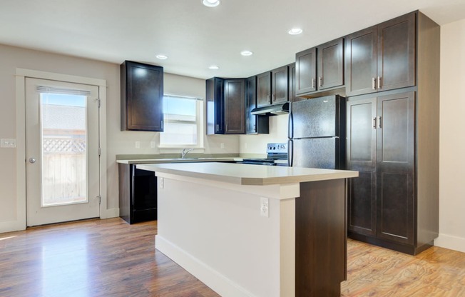 a kitchen with a large island and dark wood cabinets at Copper Pines, Bozeman, MT 