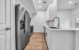 a kitchen with white cabinets and a stainless steel refrigerator