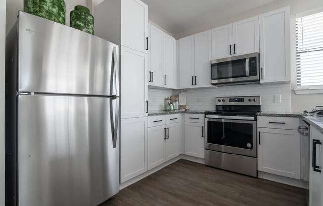 a kitchen with stainless steel appliances and white cabinets