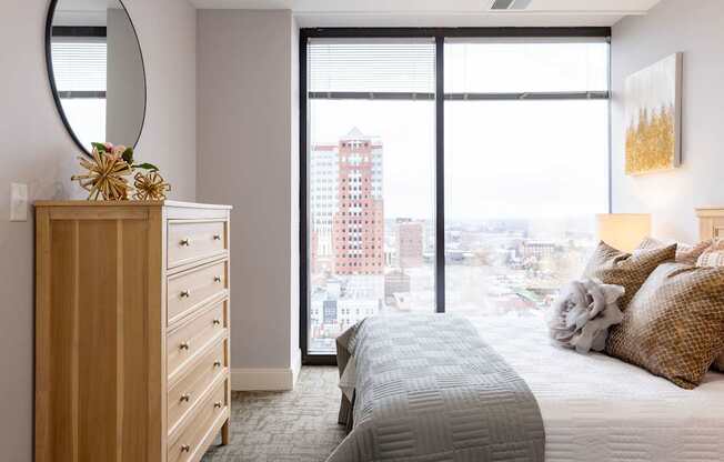 A bedroom with a large bed and a view of the city.