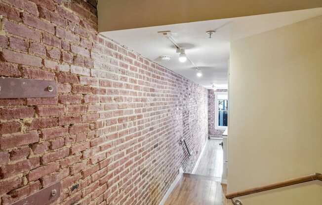 an exposed brick wall in a hallway of a house