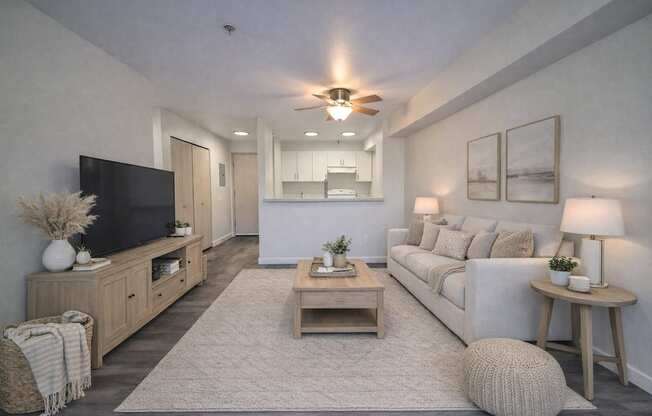 A living room with a white couch, wooden coffee table, and a flat screen TV.