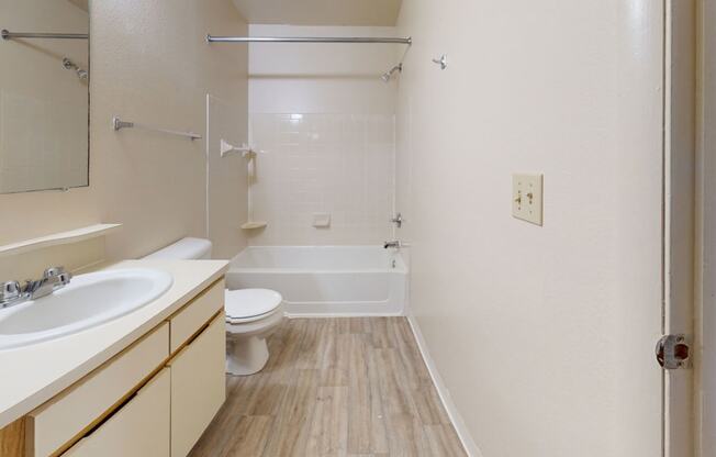 a seville bathroom with a large vanity and a shower/bath tub combination