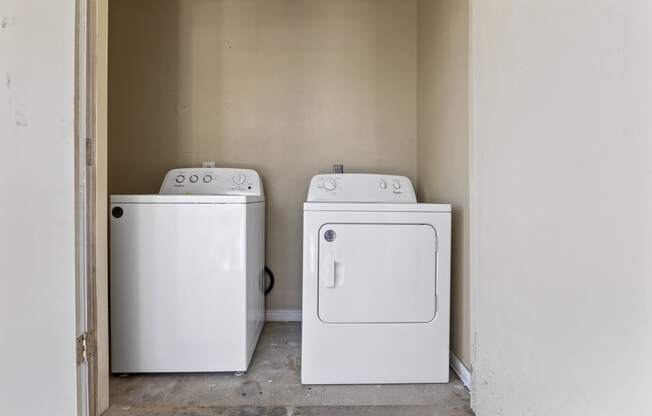 an empty laundry room with two washes and a dryer