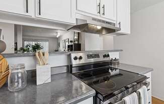 A modern kitchen with a stove top oven and white cabinets.