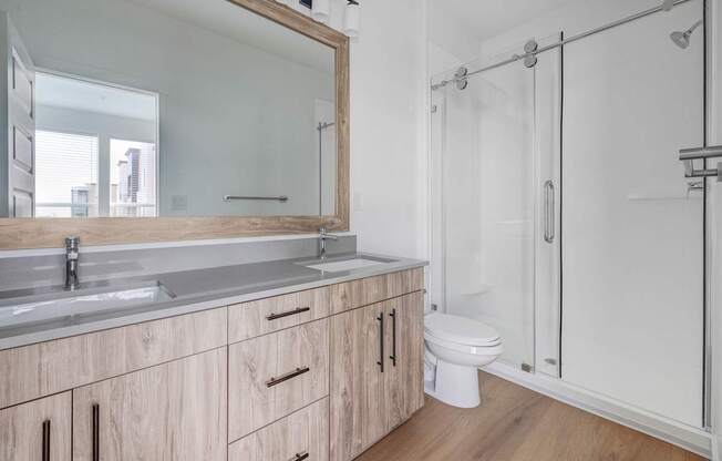 A bathroom with a sink, mirror, and toilet. at Reveal, Draper, 84020