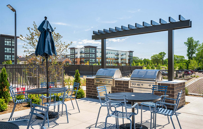 a patio with tables and chairs and an umbrella