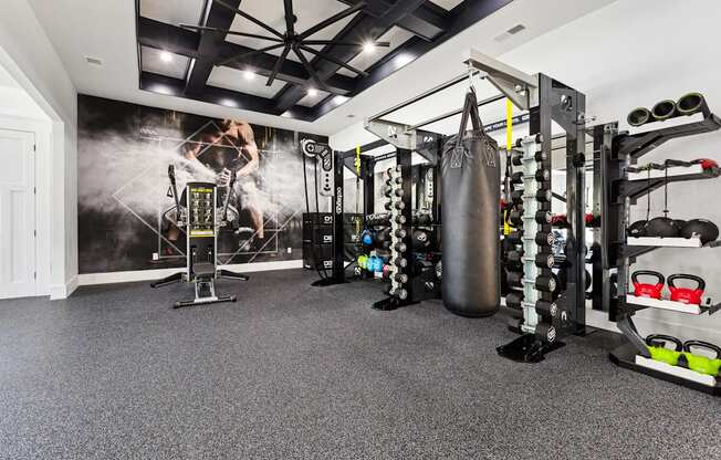 A gym with a punching bag, weights, and exercise equipment.