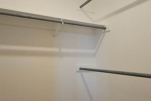 A white wall with a wooden floor and a white ceiling.