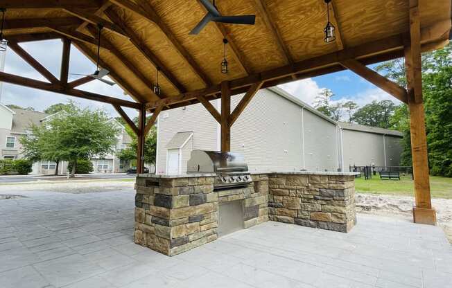 an outdoor kitchen with a grill and a fireplace