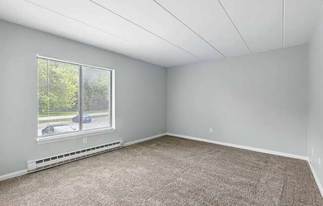 A room with a window and a car parked outside.