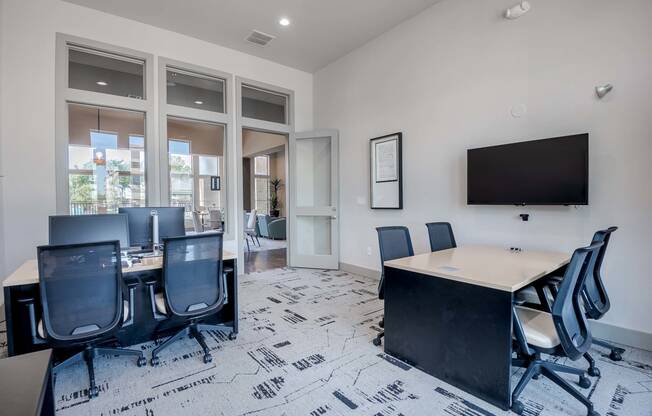 a conference room with a table and chairs and a television