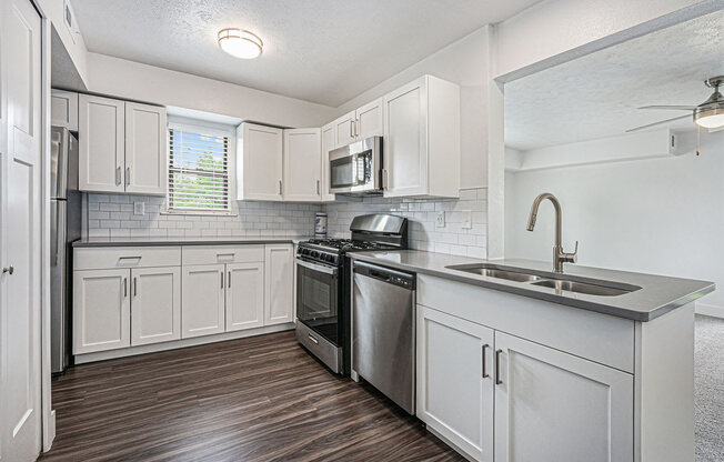 end kitchen with white cabinets and stainless steel appliances at The Crossings Apartments, Michigan, 49508