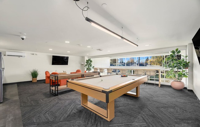 A room with a pool table and a television.